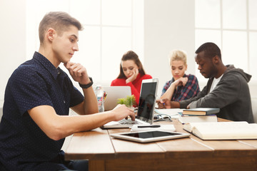 Young casual man using laptop at modern office