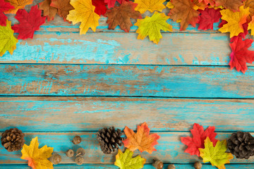 Beautiful frame composed of  autumn maple leaves with pine cones on wood plank. nature fall season...