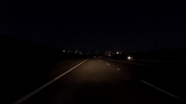 Driving on the motorway at night on Anglesey with the moon in background - Wales