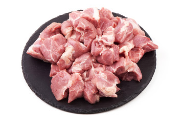Pieces of pork meat on a slate plate, isolated on white background.