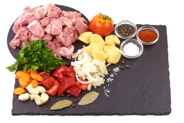 Ingredients for Hungarian goulash, isolated on white background. Place for text on a slate stone plate.