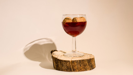 Empty glass of wine with wine stoppers (cork) inside on a white