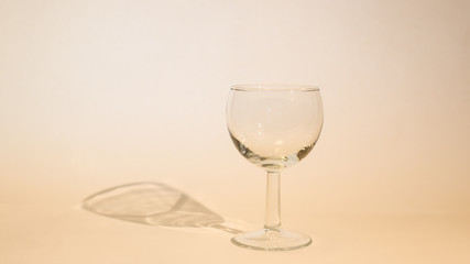 Empty glass of wine with wine stoppers (cork) inside on a white