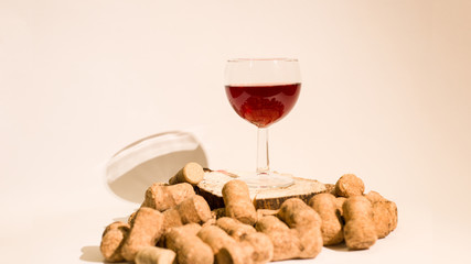 Empty glass of wine with wine stoppers (cork) inside on a white