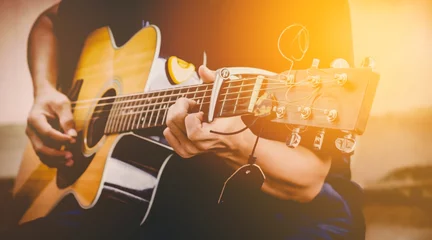 Tuinposter hand playing acoustic guitar, close up on musical instrument Relaxation Music sound hobby passion concept. © catacartphoto