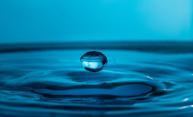 Fototapeta na wymiar single water drop splashing in a body of water