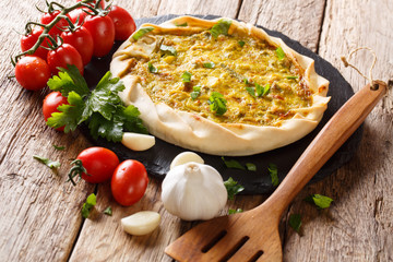 potato tart with vegetables, bacon and parsley closeup on the table. horizontal