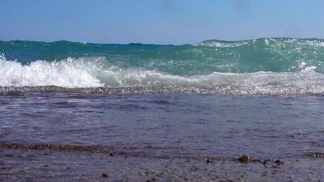 Shoot from a low angle. Sea surf close-up. The wave rushes to the camera. The wave covers the camera.
