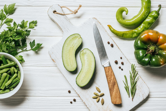 top view of cut cucumber on white wooden cutting board