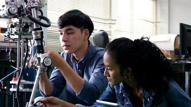 Engineering collaborating on develop of robot in laboratory together. 4K Resolution.