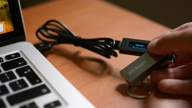 Plugging in Ledger cold hardware Bitcoin cryptocurrency wallet entering PIN code and accessing funds