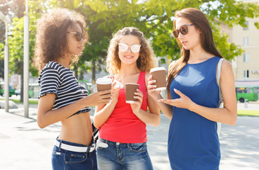 Happy girls with take away coffee outdoors