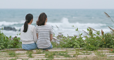 Asian women chatting and sitting at the seaside