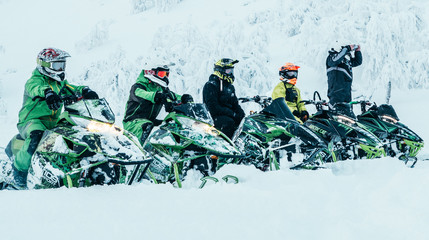 Snowmobile riders lined up ready to go