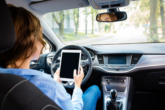 Young woman using tablet in a self-driving car - Powered by Adobe