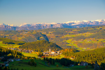 Incredible scenic view of traditional tyrol village with church in alpine valley at autumn sunny day