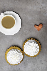 Delicious Dessert. Lemon tartlet tart with meringue and cup of hot coffee, watermelon heart on grey stone concrete table background.