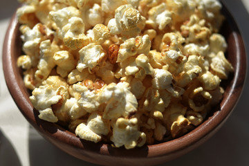 Crunchy popcorn in a wooden bowl close up. Homemade rest.