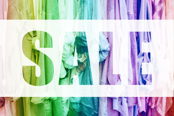 Rainbow background with jersey woman's clothes in shop. Discount concept.
