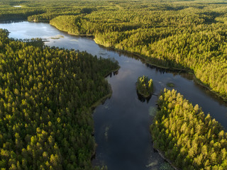 Aerial view of a lake surrounded by dense boreal aka taiga forest in Oulanka National Park, Finland