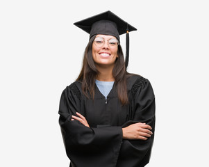 Young hispanic woman wearing graduated cap and uniform happy face smiling with crossed arms looking at the camera. Positive person.