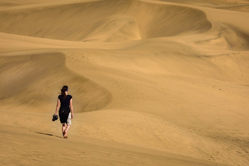 Fototapeta na wymiar Scenic View Of Alone Woman Walking On Dunes