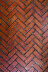 The path paved with red brick in zigzag pattern, Red stone walkway herringbone style pattern close-up on vertical shot