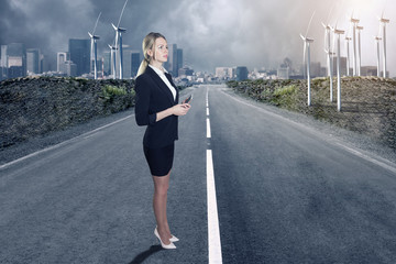 Fototapeta na wymiar Business woman and a windfarm. Green energy concept