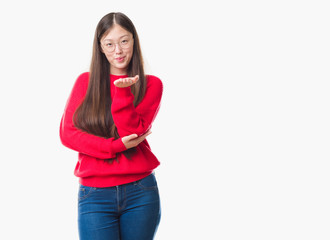 Young Chinese woman over isolated background wearing glasses looking at the camera blowing a kiss with hand on air being lovely and sexy. Love expression.