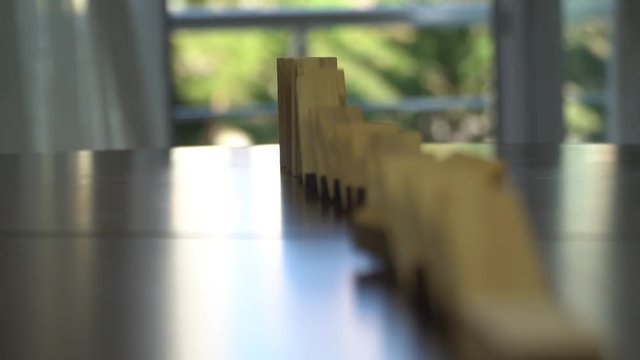 Wooden blocks falling in line domino effect business concept