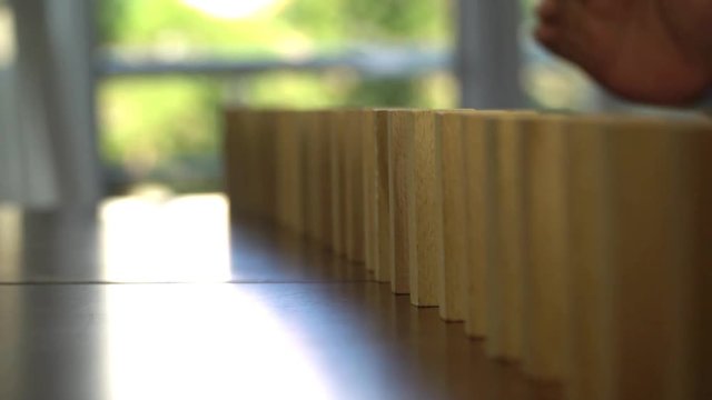 Wooden blocks falling in line domino effect business concept