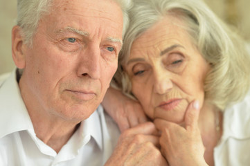 Portrait of a sad senior couple at home