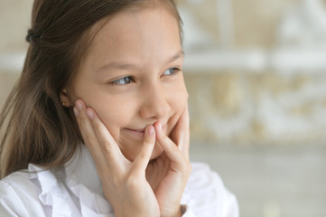 Portrait of a happy little girl in white blouse posing