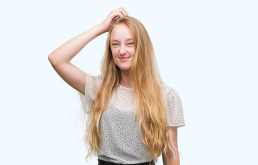 Fototapeta premium Blonde teenager woman wearing moles shirt confuse and wonder about question. Uncertain with doubt, thinking with hand on head. Pensive concept.