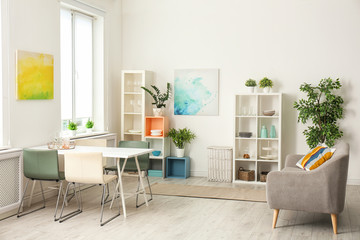 Stylish apartment interior with dining table and sofa