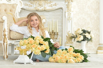 Cute curly teen girl posing with bouquet of yellow roses