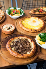 Variety of Turkish Pide Traditional food with beef, Cheese, Fried Egg and Salad.