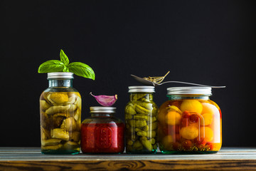 Preserved vegetables on wooden background. Autumn cans for the winter