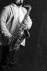 Man in hat with saxophone in studio