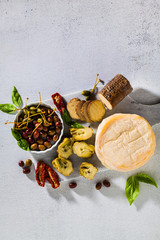 Several types of Italian cheese from Puglia and cold snacks on the table. Artichokes in oil and dried tomatoes