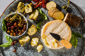Several types of Italian cheese from Puglia and cold snacks on the table. Artichokes in oil and dried tomatoes