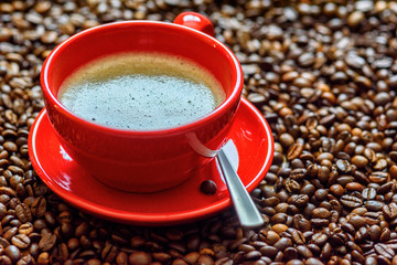 a cup of coffee on a background of coffee beans