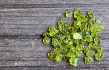 Olivine gemstone also called Peridot on old wooden background.Selective focus.