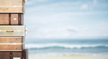 Stacked suitcases on beach background