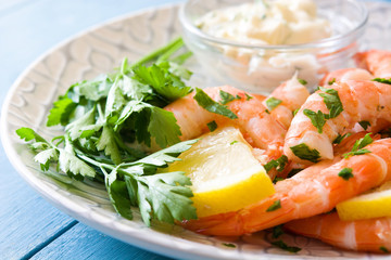 Grilled shrimps, parsley and lemon on blue wooden table. Close up

