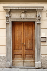 Fototapeta na wymiar porta di ingresso in legno antica facciata casa, europa