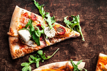 Hot pizza slice with Pepperoni, melting cheese on a rustic wooden table closeup.  Pizza Ready to Eat. Top view.