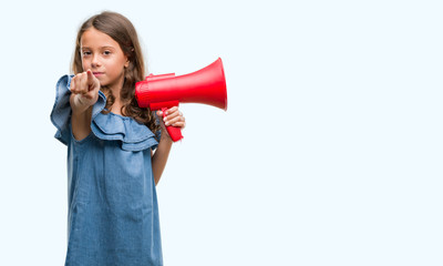 Brunette hispanic girl holding red megaphone pointing with finger to the camera and to you, hand sign, positive and confident gesture from the front
