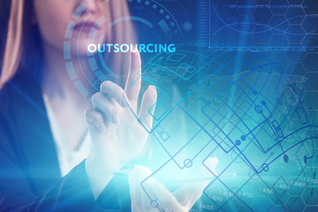 The concept of business, technology, the Internet and the network. A young entrepreneur working on a virtual screen of the future and sees the inscription: Outsourcing