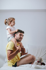 Father and daughter playing on bed